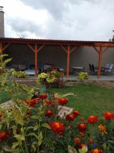 een tuin met een paviljoen met stoelen en bloemen bij Apartmány U splavu in Veselí nad Moravou