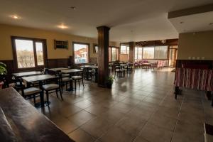 a restaurant with tables and chairs in a room at Hosteria Puerto San Julian in El Calafate