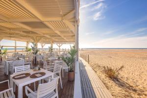 ein Restaurant am Strand mit einem Tisch und Stühlen in der Unterkunft Meliá Zahara Resort & Villas in Zahara de los Atunes