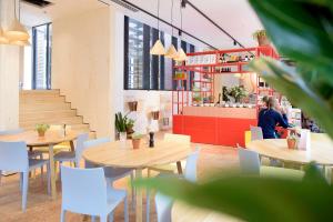 a woman sitting at a table in a restaurant at The Green Elephant Hostel & Spa in Maastricht