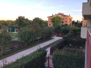 Vistas a una calle con un edificio y árboles en Res. Chalet a 10 min. da Rho Fiera e Stadio Meazza, en Milán