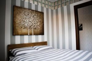 a bedroom with a bed with a striped wall at Res. Chalet a 10 min. da Rho Fiera e Stadio Meazza in Milan