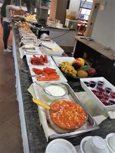 una línea de buffet con muchos tipos diferentes de comida en La Residence Flat Hotel, en Goiânia