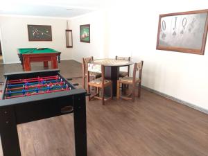 a living room with a table and a table and a pool table at Hotel Geranium in Balneário Camboriú