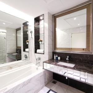 a bathroom with a tub and a sink and a mirror at Sky Pool Elegant Suite @ Sri Hartamas in Kuala Lumpur