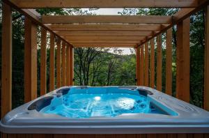 a hot tub on a deck with a pergola at TreeHouses Noszvaj in Noszvaj