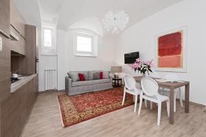 sala de estar con mesa y sofá en BMGA l Mon Amour San Giovanni Apartment, en Roma