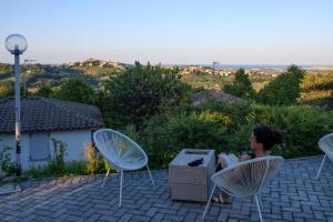 eine Frau, die auf einem Stuhl auf einer Terrasse sitzt in der Unterkunft Camping Village Mar y Sierra in San Costanzo