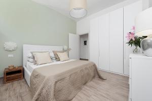 Dormitorio blanco con cama y mesa en BMGA l Mon Amour San Giovanni Apartment, en Roma