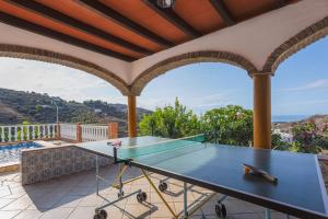 una mesa de ping pong en el balcón de una casa en Cortijo Tomé, en Torrox