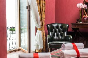 una silla de cuero negro en una habitación con ventana en Lancaster Court Hotel, en San Petersburgo