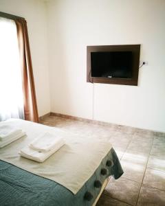 a bedroom with a bed with a flat screen tv on the wall at Casa check in Dpto 2 a 4 pers in Neuquén