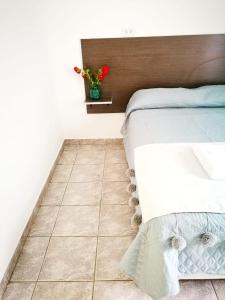 a bedroom with a bed and a tiled floor at Casa check in Dpto 2 a 4 pers in Neuquén