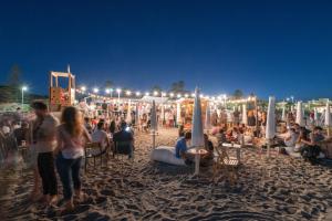 a crowd of people on a beach at night at Le Palmette Suites in Cagliari