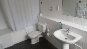 a white bathroom with a toilet and a sink at Keswick Country House Hotel in Keswick