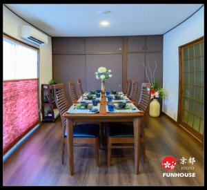 a dining room with a table with chairs and flowers on it at Funhouse Kaori in Kami-tobachō