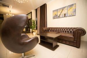 a living room with a leather couch and a table at Meliton Hotel in Krasnodar