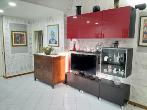 a living room with a television and red cabinets at A due passi in Arezzo