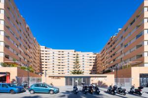 un groupe de motocycles garés devant de grands bâtiments dans l'établissement Araucaria Garden & Parking, à Malaga