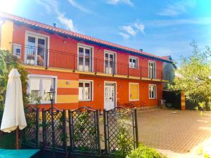 una casa colorida con una valla y una sombrilla en Il nido dei gufi en San Maurizio Canavese