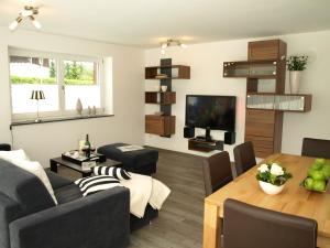 ein Wohnzimmer mit einem Sofa und einem Tisch in der Unterkunft Alpenflair Ferienwohnungen Whg 307 Edel-Weiß in Oberstdorf