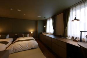 有田的住宿－田川溫泉陽光酒店，一间卧室设有一张床和一个大窗户