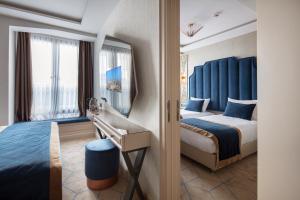 une chambre d'hôtel avec deux lits et un miroir dans l'établissement Danis Hotel & Spa Istanbul - Old City, à Istanbul