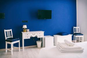 a blue room with a bed and a desk and chairs at FANNY B&B in Catania