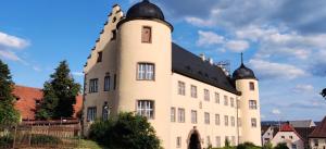 a large white building with a black roof at Ferienwohnung am Hollergraben in Oberschwarzach