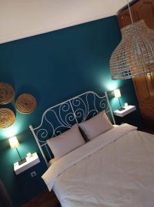 een slaapkamer met een wit bed en een blauwe muur bij Fenia's Apartment in Thessaloniki