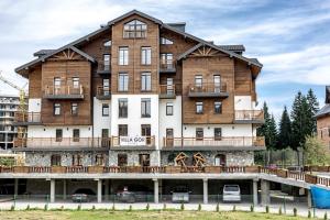 a large wooden building with a large white building at Villa Gor Apartments in Bukovel