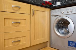 a kitchen with a washer and a washing machine at Velvet 2-bedroom apartment, Clockhouse, Hoddesdon in Hoddesdon