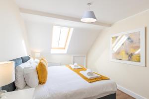 een slaapkamer met een bed met witte lakens en een raam bij Velvet 2-bedroom apartment, Clockhouse, Hoddesdon in Hoddesdon