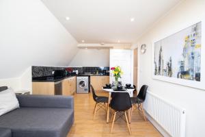 a living room with a couch and a table and chairs at Velvet 2-bedroom apartment, Clockhouse, Hoddesdon in Hoddesdon