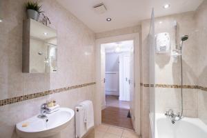 a bathroom with a sink and a mirror and a tub at Velvet 2-bedroom apartment, Clockhouse, Hoddesdon in Hoddesdon +31 photos