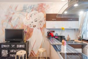 a kitchen with a mural of a woman on the wall at Second home in heart of Bratislava in Bratislava