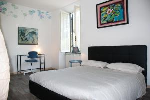 ein Schlafzimmer mit einem großen Bett und einem blauen Stuhl in der Unterkunft Marino Le coccinelle in Marino