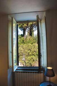 ein Fenster in einem Zimmer mit Blick auf einen Baum in der Unterkunft Marino Le coccinelle in Marino