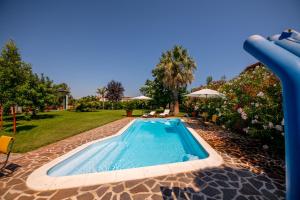 een zwembad met een glijbaan in een tuin bij Villa Tigli Luxury B&B in Martinsicuro