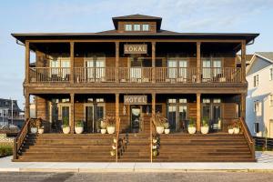 a large wooden building with a hotel sign on it at Lokal Hotel Cape May in Cape May