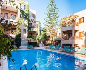 a swimming pool in the middle of a building with chairs at Anna Maria in Malia