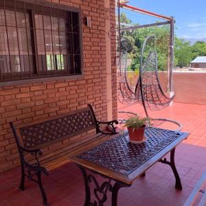 una panchina e un tavolo con una pianta in vaso su un patio di Alquiler temporario Mendoza a Mendoza