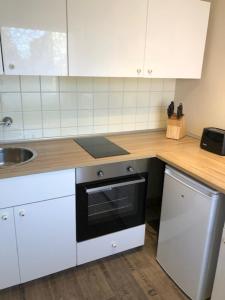 a kitchen with white cabinets and a stove and a sink at Monteur Design Wohnung in Rodenbach