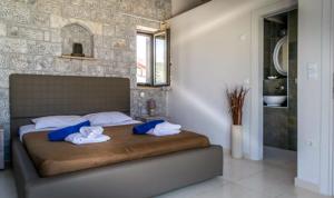 a bedroom with a bed with towels on it at Villa Elly in Stoupa +26 photos