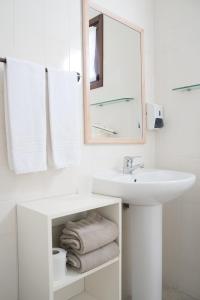 een badkamer met een wastafel, een spiegel en handdoeken bij Casa das Proteas in São Jorge