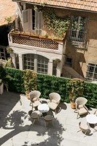 un patio con mesas y sillas frente a un edificio en Hôtel Cézanne Boutique-Hôtel en Aix-en-Provence