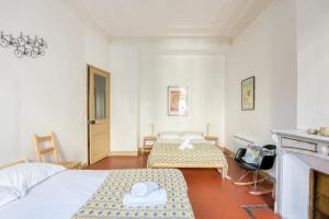 マルセイユにあるNOCNOC - L'Haussmanienのベッド2台と暖炉付きのホテルルームです。