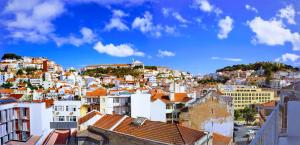 uitzicht op een stad met witte gebouwen bij Amazing Downtown Apt with small balcony with view over the castle in Lissabon