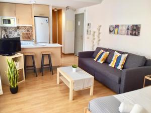 a living room with a couch and a kitchen at De la Mota Charming Room - parking free in Málaga