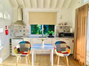 een keuken met een tafel en 2 stoelen bij Azores Casa Atlantis in Nordeste